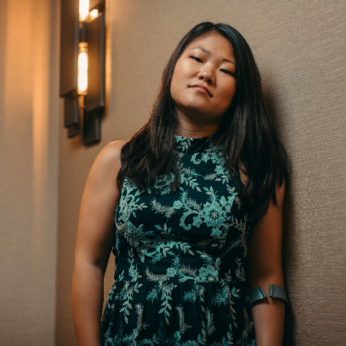 2021 Year in Review_In the News CNBC Alyse Brewer, an Asian woman with long dark hair, a turquoise and black patterned dress, and a left arm crutch.